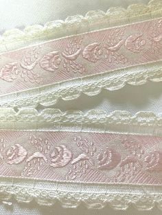 three different types of laces on white fabric with pink and gold trimmings