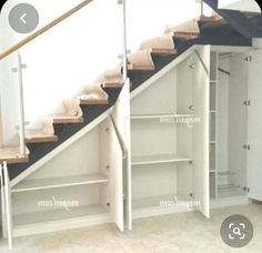 an empty room with some shelves and stairs in it's center, next to a closet