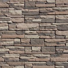 a stone wall that has been made out of various types of stones and is brown