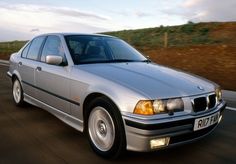 a silver car is driving down the road