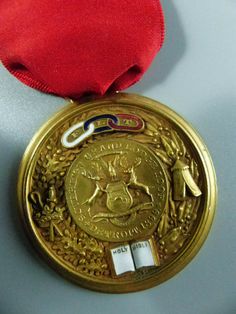 a gold medal with a red ribbon around it