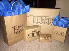 three brown paper bags with blue handles are sitting on the floor