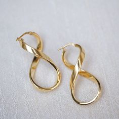 925 Sterling Silver Gold Infinity Hoop Earrings * Material: Vermeil (1 micron 18K Gold on Solid Sterling Silver)  * Weight: 5.2 g * Finish: 18K Gold * Dimensions: 43 mm* 21 mm OTHER INFORMATION * Sold in 2 pieces * Made in Italy high quality gold vermeil infinity hoop earrings * Lightweight, classy and Timeless. * Tarnish-free * Nickel and Lead-free * Hypoallergenic / Made for Sensitive Skin * All items are nicely packaged ready to gift in jewelry pouches. * Need more information? Feel free to contact us. We are fast to reply :) OTHER PRODUCTS https://www.etsy.com/shop/MuseandQueen OUR COMMUNITY * IG: @museandqueen * FB: https://www.facebook.com/museandqueen CLICK BELOW IN *FAQs* SECTION TO SEE * about RETURNS and EXCHANGE * care instruction * gift wrapping and packaging * shipment ------- Infinity Hoop Earrings, Infinity Hoop, Symbol Earrings, Twisted Hoop Earrings, Infinity Earrings, Jewelry Pouches, Hoops Gold, Hoop Earrings Gold, Figure 8