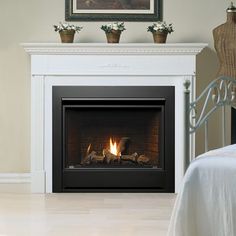 a fire place in a bedroom with white walls and wood flooring on the side