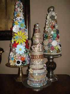 three small christmas trees sitting on top of a table