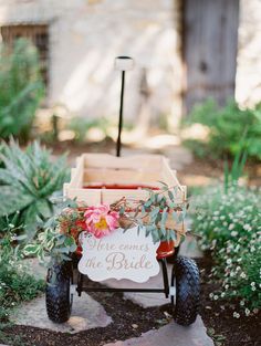 a wooden cart with flowers on it and a sign that says welcome to the bride