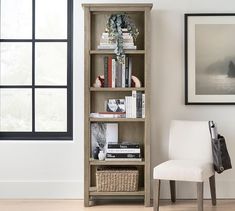 a white chair sitting next to a book shelf filled with books