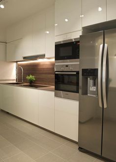 a modern kitchen with stainless steel appliances and white cabinets