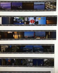 multiple film strips with images of city lights and buildings in the background, all lined up against a white wall