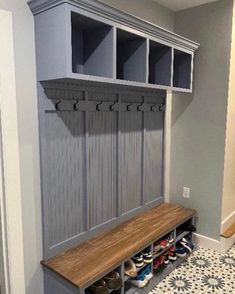 a wooden bench sitting next to a wall filled with shoes