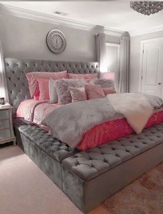 a large bed with pink and grey comforters