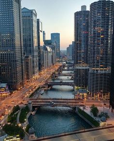 an aerial view of a river running through a city with tall buildings in the background