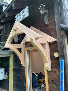 the outside of a wooden building with a sign on it's roof that says under cover