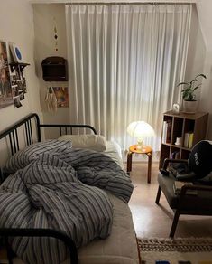 an unmade bed in a small room