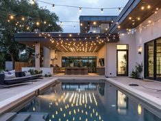 an outdoor pool with lights strung over it