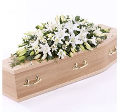 a wooden box filled with white flowers and greenery