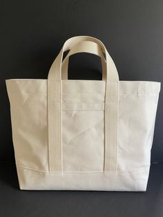 "Canvas tote bag, classic in styling. Heavy 18 oz cotton duck will serve you well as a stylish canvas tote for just about anything! Use it as a shopping bag, a beach bag, overnight bag. The bag has double bottom, sturdy 1.5\" wide handles, with webbing that is sewn around the bottom of the bag. Key hook, exterior slip pocket. Choose from 8 colors. Dark Olive and Natural are shown in photos. Dimensions: 22\" wide across top 14\" high 6\" deep 16\" x 6\" bottom Handles are 6\" drop, 14\" long Exte Cotton Canvas Beach Bag, Canvas Shopper Bag, Travel Laundry Bag, Canvas Duffle Bag, Tote Bag With Pockets, Classic Tote Bag, Creative Bag, Art Album, Fabric Tote Bags