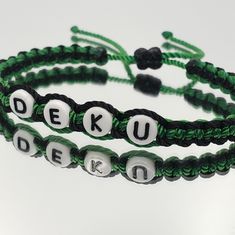 two green and white beaded bracelets with the words deku written on them