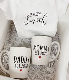 two coffee mugs in a gift box with the words baby south and mommy est 2020 printed on them