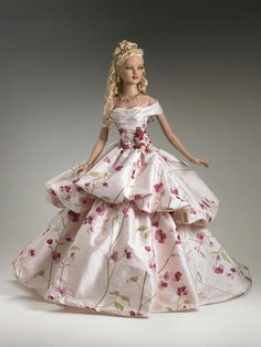 a barbie doll dressed in a white dress with pink flowers on it's skirt