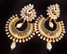 If you like something rare and artistic , which also is stylish this is the piece to own. **Pearl and Gold earrings **Chand bali style Earrings ** Kundan stones are used which makes the piece unique. ** Length of earring 3.5 inches ** Post earrings ** Lightweight as compared to what they may seem Kundan is bezel setting of gemstones in 22K gold leaf. This art form was made famous by the royals mostly during the Mughal era in India. Be a part of this legendary art by owning this piece of art. ONE Luxury Round Chandbalis With Intricate Design, Luxury Kundan Chandbali Chandelier Earrings, Luxury Gold Chandbali Chandelier Earrings, Luxury Gold Kundan Chandelier Earrings, White Chandbalis With Intricate Design As Gift, White Temple Jewelry Chandbalis As Gift, White Fusion Style Chandbalis For Diwali, White Intricate Design Danglers As Gift, White Intricate Danglers For Gift