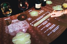 a table with wine glasses and menus on it that are projected onto the table