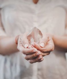 a woman holding a piece of glass in her hands, with both hands on top of it