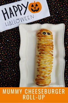 a cheeseburger roll - up on a plate with a happy halloween sign in the background