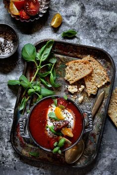 a bowl of tomato soup with crackers on the side