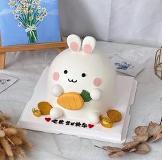 there is a cake that looks like a bunny holding a piece of fruit