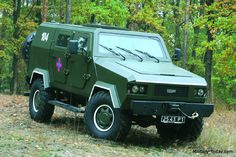 a green armored vehicle parked in the woods