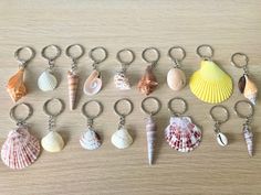 a bunch of seashells that are sitting on a wooden table with one keychain