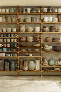 the shelves are filled with different types of pottery