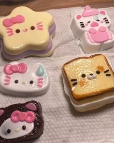 four hello kitty toasters on a towel with one slice cut in half and the other made out of bread