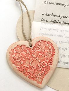 a red heart shaped wooden ornament sitting on top of a piece of paper