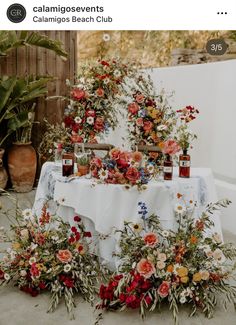 an image of a table with flowers on it and candles in the middle for centerpieces