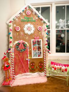 a gingerbread house decorated with candy canes and candies for the holiday season