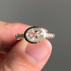 a person holding a ring with a diamond in it's middle and two diamonds on the side