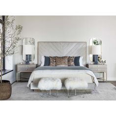 a bedroom with a bed, nightstands and two lamps