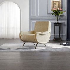 a chair sitting on top of a hard wood floor next to a vase filled with flowers