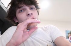 a young man is taking a bite out of his doughnut while sitting down in front of him