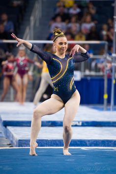 a woman in a blue leotard doing gymnastics