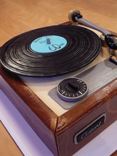 an old fashioned record player sitting on top of a wooden table