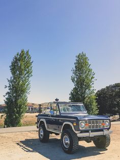 a black truck parked on top of a dirt field