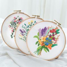 three embroidery hoop frames with flowers on them