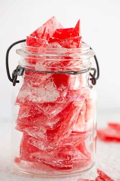 a glass jar filled with red sugar cubes