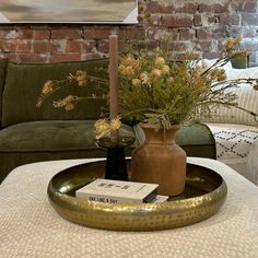 a living room filled with furniture and flowers on top of a coffee table in front of a couch