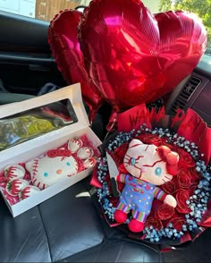 two heart shaped balloons in the back seat of a car and a hello kitty bouquet