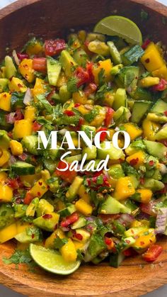 mango salad with avocado and tomatoes in a wooden bowl