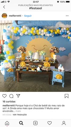 the table is set up for a baby shower with yellow and blue balloons on it